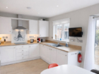 Kitchen at The Rock cottage with under-cabinet lighting, garden view through the window, and red accent stool