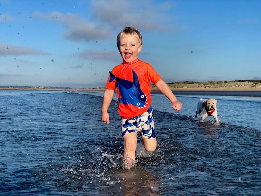 Child and dog playing at one of the best sandy beaches near London