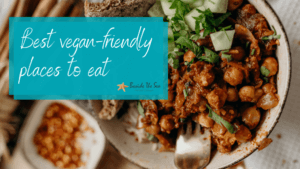 Plate of vegan food used on banner for best vegan-friendly places to eat blog post