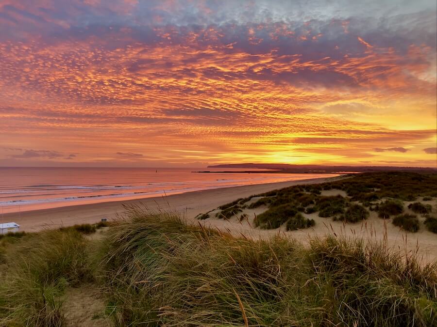 Camber Sands autumn breaks with fiery sunset over the dunes