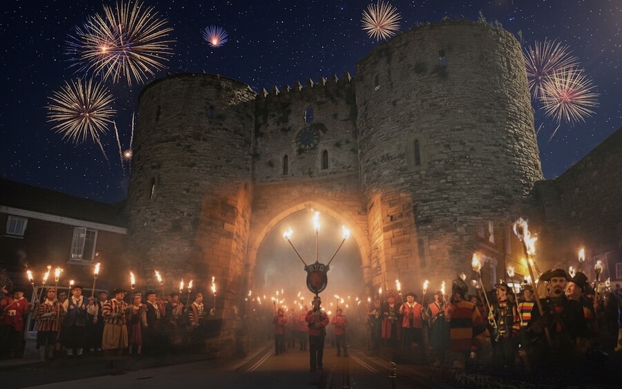 Rye Bonfire Boys procession at Rye Bonfire with flaming torches walking through landgate