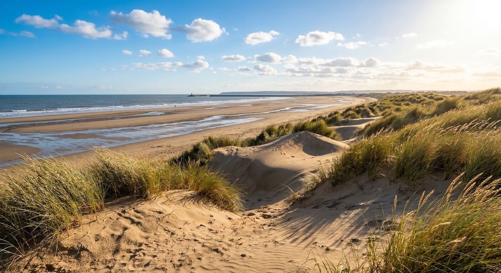 Sand dunes and beach at Camber Sands on a sunny day