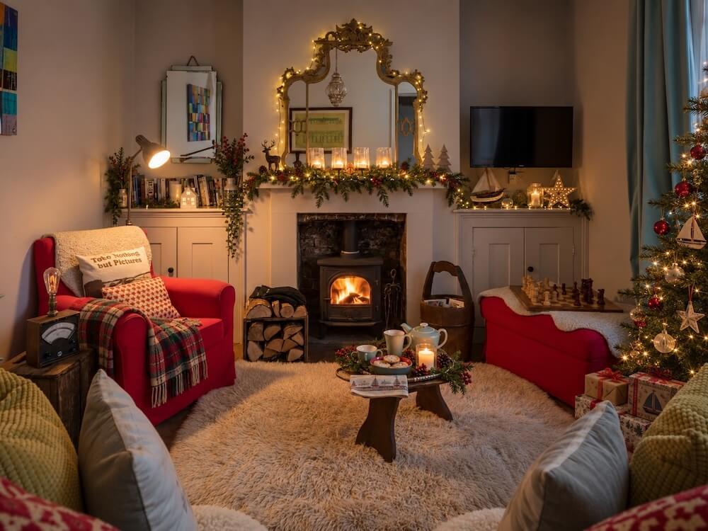 Christmas cottages in Camber Sands: the log burner lit, a decorated tree and candles on the mantelpiece at Coastguards Lookout