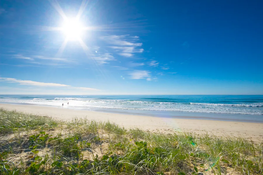 A summer day at Camber Sands beach with blue skies and golden sand.