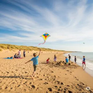Things to do in Camber Sands with kids — playing on the beach with dunes in the background