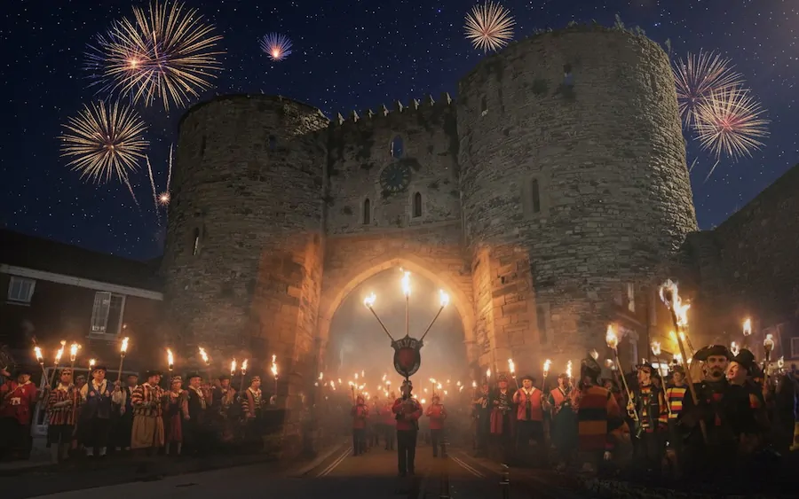 Rye Bonfire Boys procession at Rye Bonfire with flaming torches walking through landgate