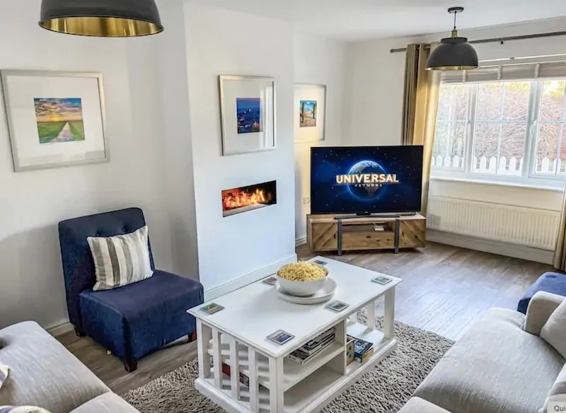 Family enjoying a movie in a cosy cottage on an October half-term Camber Sands getaway
